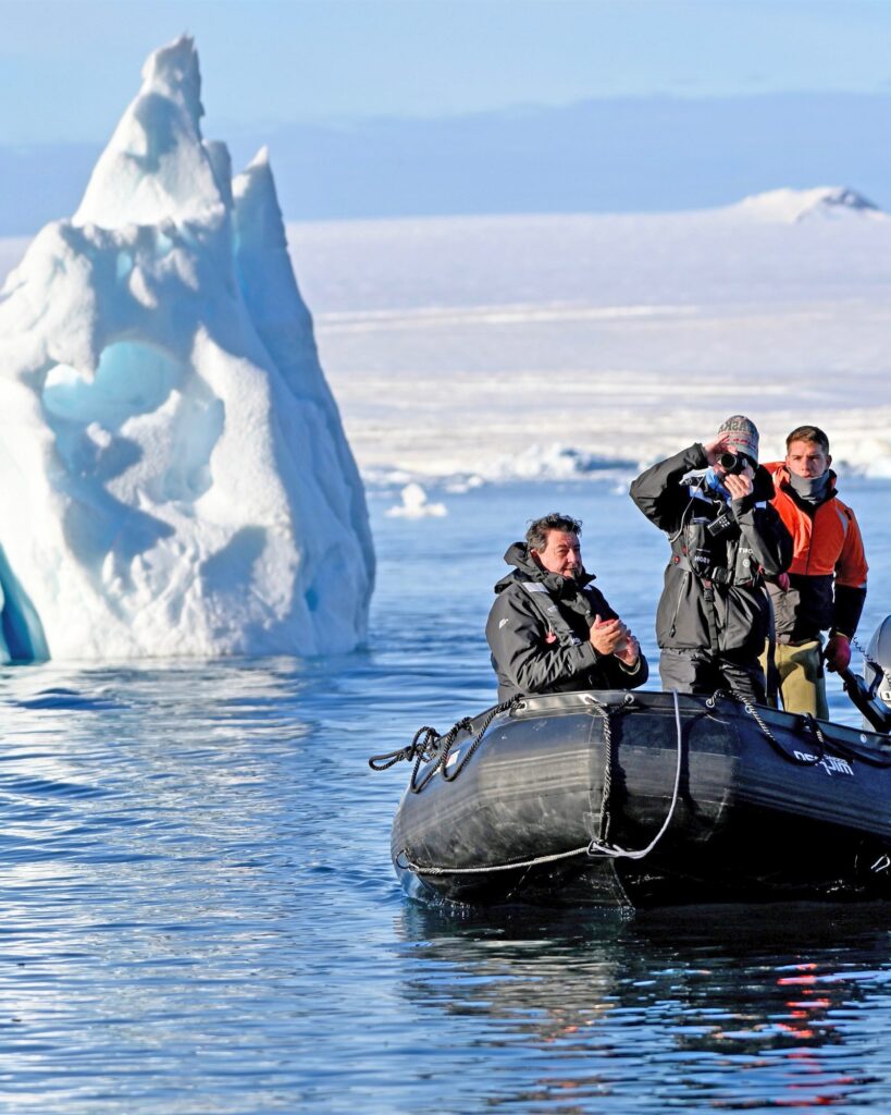 Guests in a Zodiac beside an iceberg in Antarctica